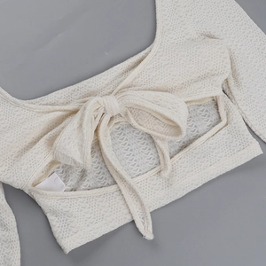 Vue détaillée du haut blanc cassé texturé avec un grand nœud papillon à l'arrière chic