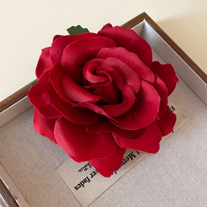 Detailed macro view of large dark red handmade fabric rose petal layers and satin texture