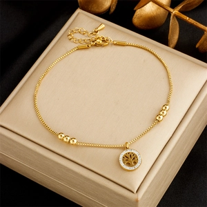 Golden titanium steel tree of life anklet with rhinestones on a gold jewelry box
