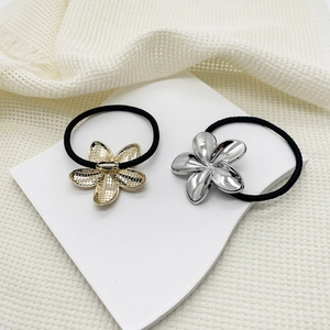 Detail of alloy flower hair ties in gold textured and silver smooth finishes