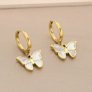 Detailed macro view of golden butterfly earrings with white shell inlay and round hoops