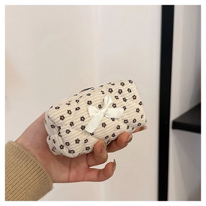 Close-up of floral corduroy mini makeup pouch with a cute white bow detail