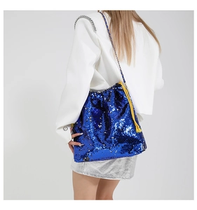 Macro detail of sparkly blue sequin bucket bag featuring contrasting yellow woven drawstrings