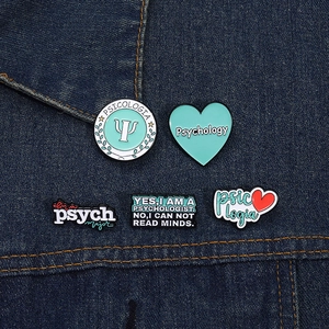 Detailed view of enamel psychology pins set on deep blue denim fabric background