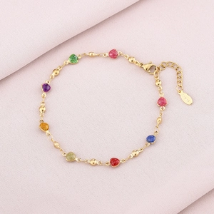 Detailed macro of gold-plated stainless steel bracelet featuring colorful heart-shaped charms