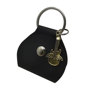 Detail of black leather guitar pick pouch with silver snap and gold wing pendant