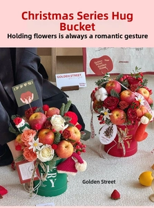 Detail of Christmas gift bucket with red roses, apples, pine cones and plush Santa doll