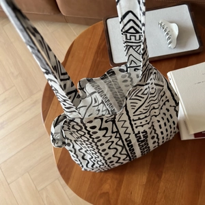 Détail d'un sac cabas en lin bohème avec des imprimés géométriques noirs et blancs