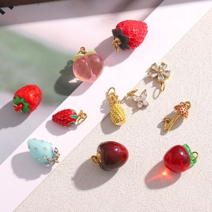 Détail de breloques en plaqué or 18 carats en forme de fruits et fleurs avec émail coloré