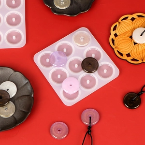 Macro view of a 9-hole silicone mold for DIY resin pendant crafting with finished pieces