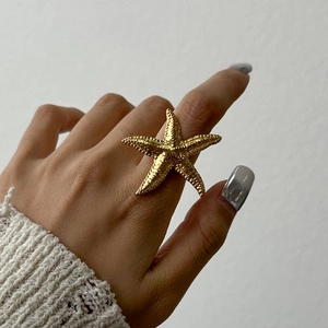 Detailed view of large gold starfish ring with unique textured surface and modern design