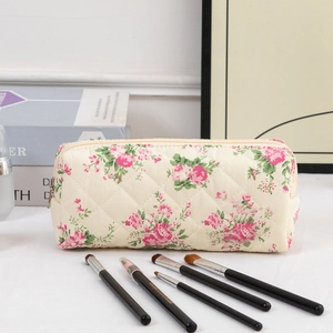 Close-up of quilted floral cotton cosmetic bag with pink roses and metal zipper detail