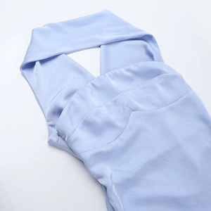 Detail of light blue satin dress showing halter neck cut and pleated bust design texture
