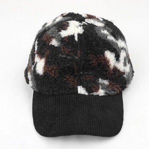 Close-up of winter baseball cap featuring camo plush fabric and black corduroy brim