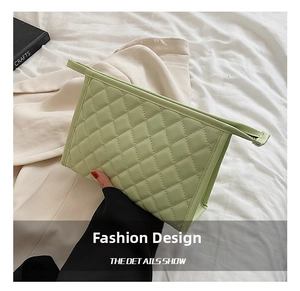 Detail view of light green quilted makeup bag showing PU leather texture and neat stitching