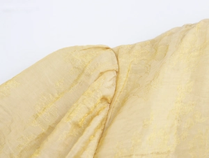 Détail macro du tissu en soie jaune clair avec d'élégants motifs jacquard floraux