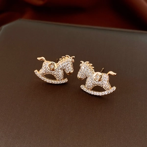 Macro shot of gold-plated rocking horse stud earrings with white zircon micro-pave setting
