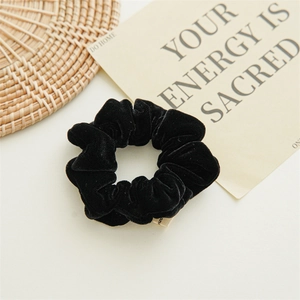 Detail of premium black velvet scrunchie texture with elegant fabric pleats for women