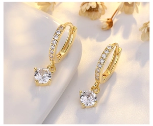 Detailed view of gold hoop earrings with sparkling round zircon charms and floral accents