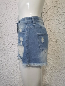 Detalle de pantalones cortos vaqueros azul claro con agujeros y dobladillos deshilachados