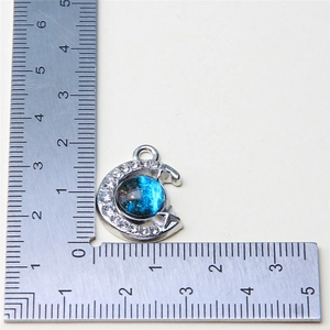 Measurement of star and moon pendant with blue cosmic gem showing 22mm diameter size