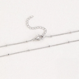 Close-up of silver-plated copper bead chain with lobster clasp and extension link