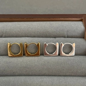 Minimalist 925 silver cat ear hoop earrings in gold and silver finish on a tray