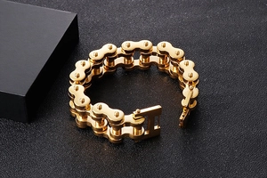 Detail of a 22mm gold stainless steel bike chain bracelet with a heavy industrial clasp