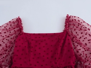 Détail de la robe à col carré avec manches bouffantes en mesh à motifs de cœurs