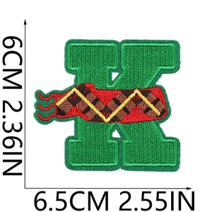 Detail of green embroidered letter K patch with Christmas patterns and dimensions