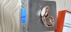 Detail showing the ladies' rhinestone star quartz watch weighing 51.4g on a digital scale
