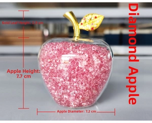 Pink crystal filled glass apple ornament with gold leaves measuring 7.7 cm in height