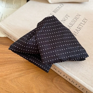 Detailed view of the black and white polka dot fabric texture on the hair accessory