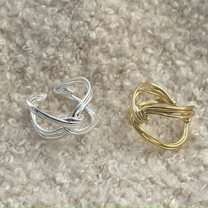 Macro shot of 925 sterling silver knotted rings in gold and silver on soft fleece surface