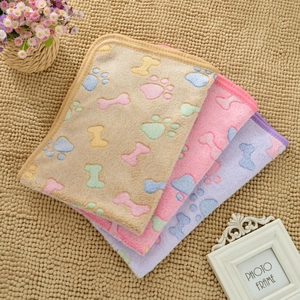 Close-up of thick flannel pet blankets with bone and paw prints in brown, pink and purple