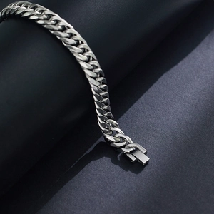 Dettaglio del bracciale a maglia cubana argento con chiusura rettangolare su nero