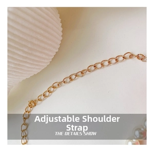 Detail of adjustable gold metal chain strap with white pearl accents for girls' handbags