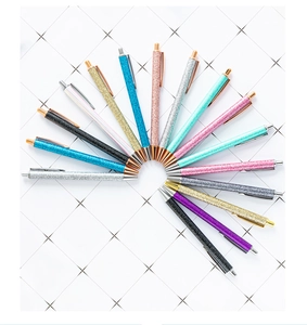 Close-up of colorful glitter ballpoint pens with metal clips in a fan-shaped arrangement