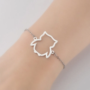 Detail of a minimalist silver stainless steel bracelet featuring an owl hollow pendant
