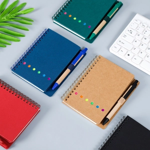Spiralnotizbuch-Set mit Stift in verschiedenen Farben auf einem sauberen Schreibtisch