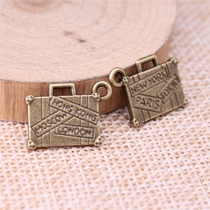 Retro bronze alloy suitcase charms featuring embossed international city names