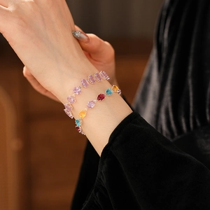 Detail of colorful oval zircon bracelets with silver claw settings on a model's wrist
