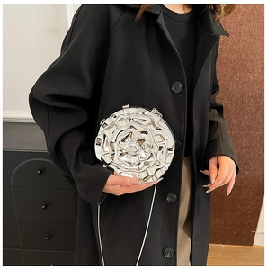 Detail of silver rose flower shaped crossbody bag with layered metallic petals and chain