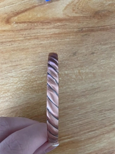 Close-up of adjustable copper magnetic therapy bracelet with twisted metal texture