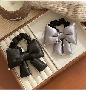 Detail of elegant black and silver satin bow hair ties with sparkling rhinestones decoration