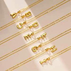 Polished gold 3D bubble initial necklaces with thin chains in an elegant group layout