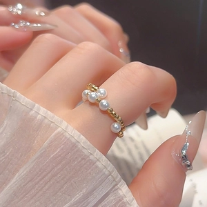 Detailed view of handmade beaded ring featuring alternating gold beads and white pearls