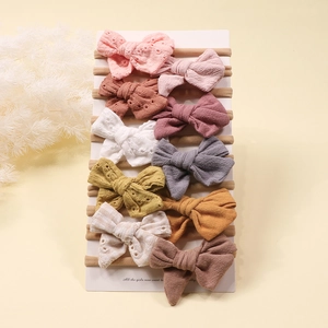 Close-up of 10-piece baby bow headbands featuring embroidered cotton and knit textures