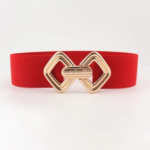 Détail d'une ceinture élastique rouge avec boucle géométrique dorée et texture fine