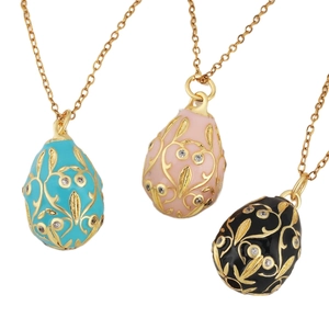 Three colorful Fabergé style enamel egg pendants with gold floral patterns and crystals